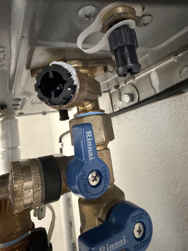 Mineral buildup around tankless water heater inlet filter — sign of overdue flush — Irvine and Lake Forest hard water